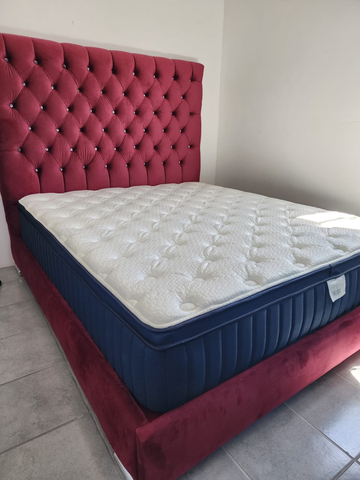 Cabecera capitoné en color vino con base azul marino