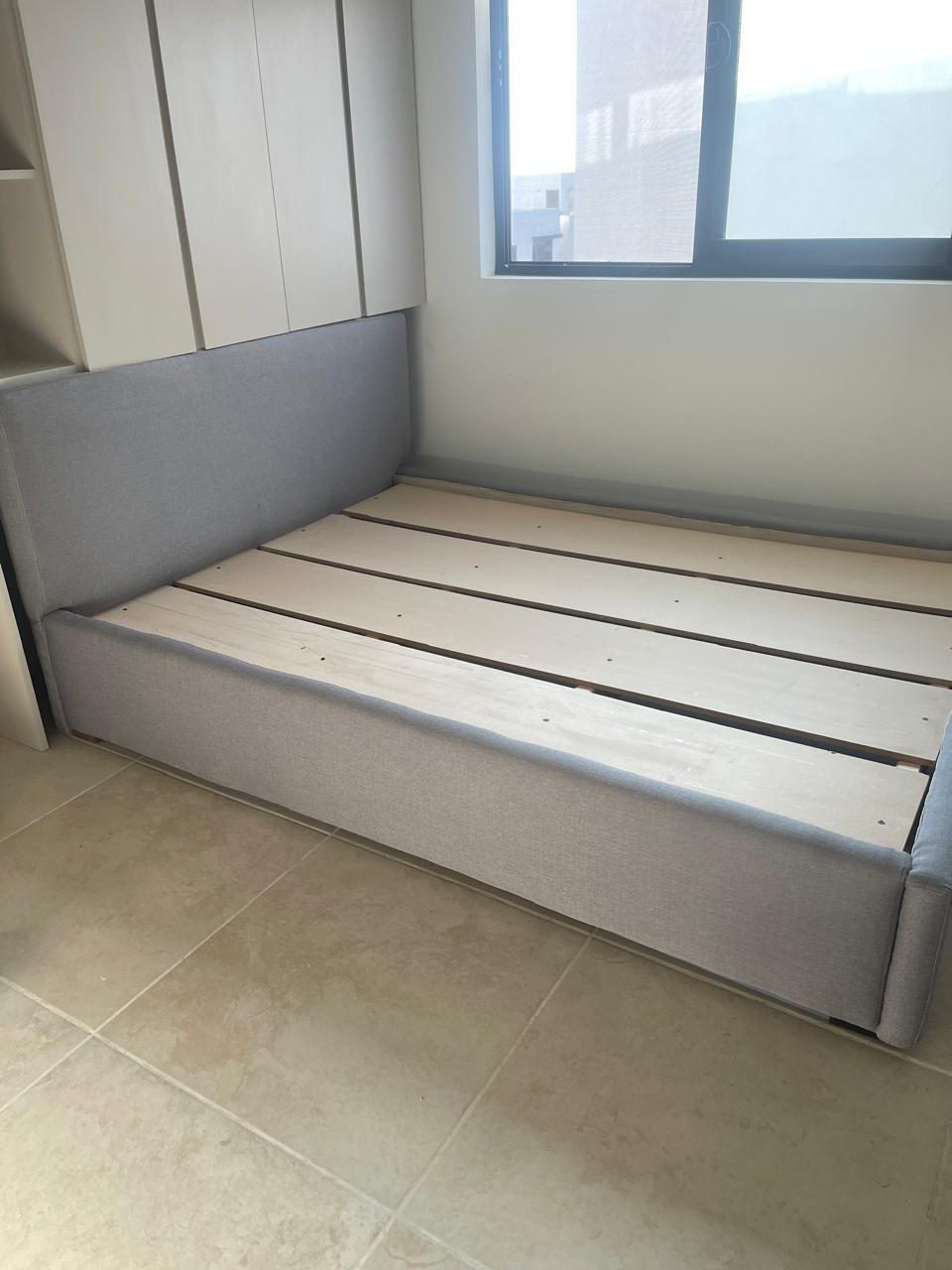 Base tapizada en gris junto a ventana