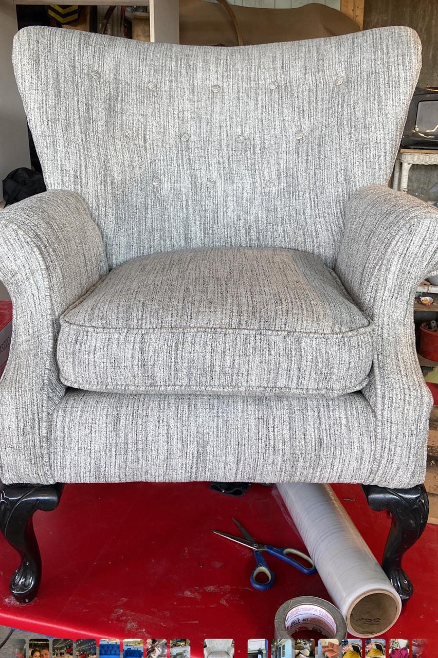 Sillón tapizado en tela gris jaspeada con botonadura