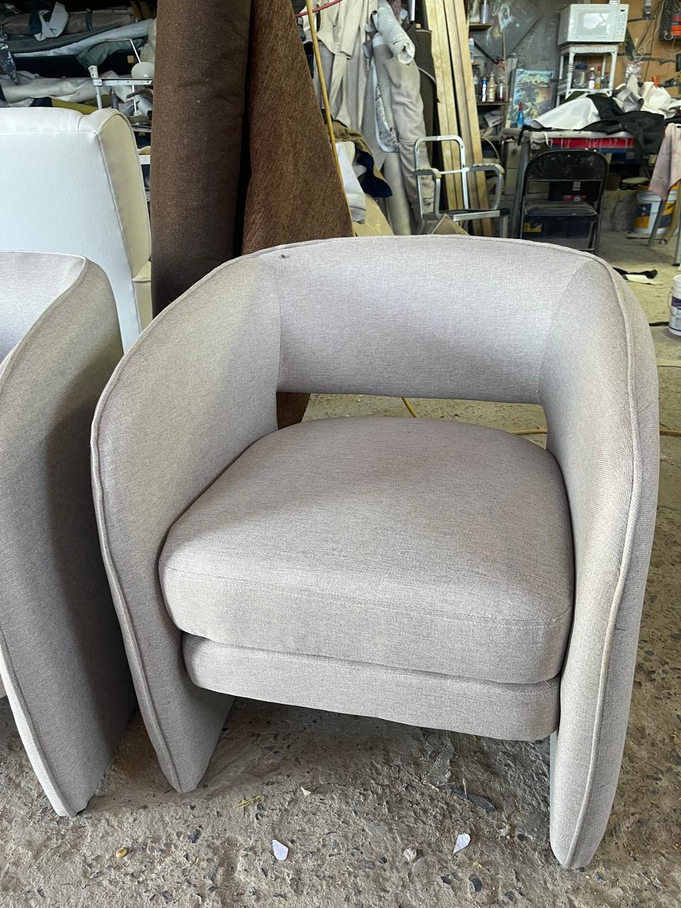 Sillón tapizado en tela beige, diseño moderno