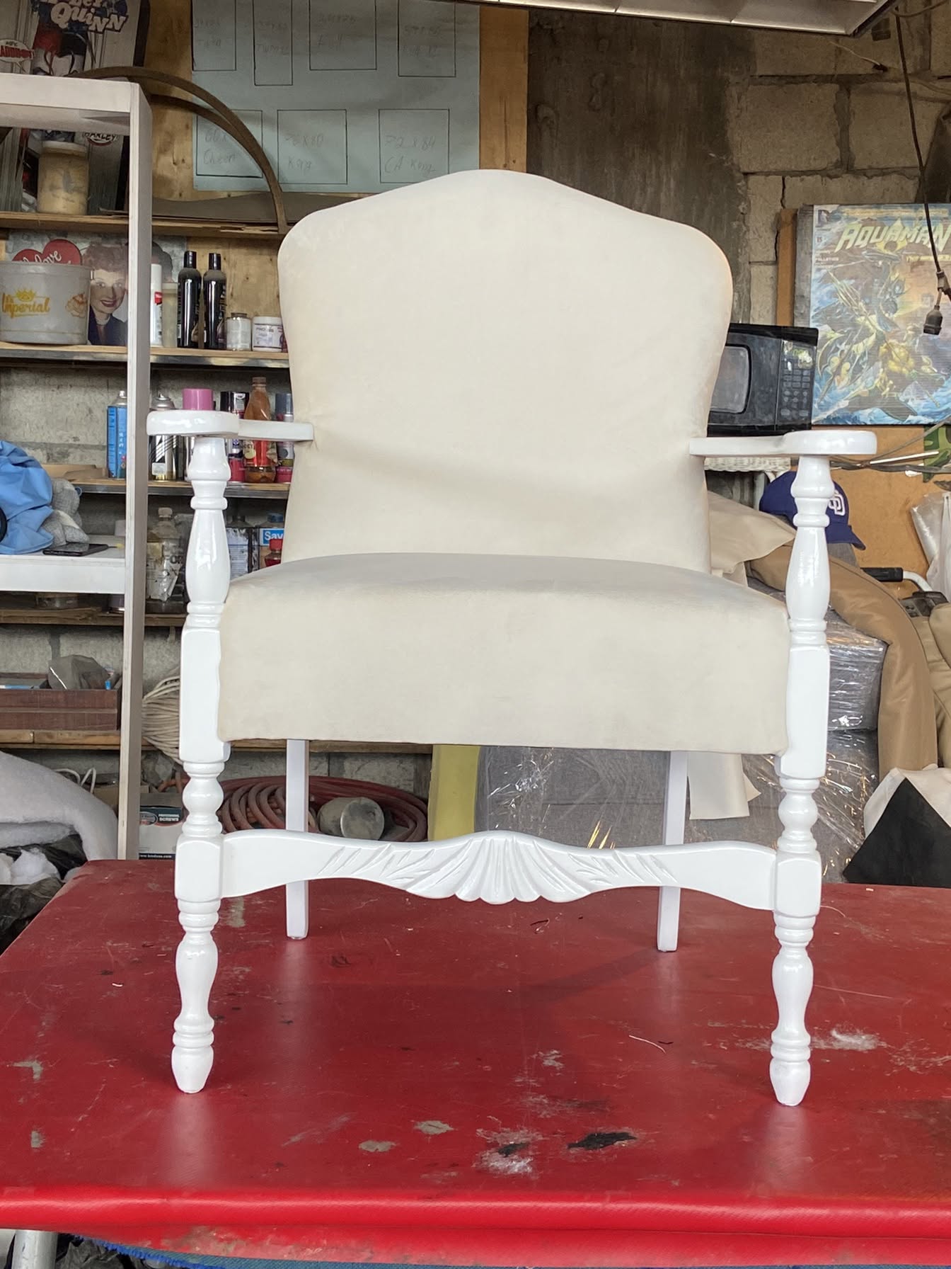 Sillón tapizado en color crema con base blanca