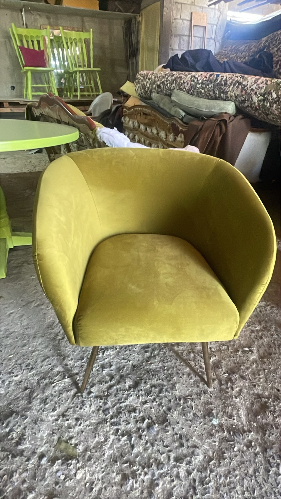 Sillón tapizado en terciopelo color mostaza con patas doradas