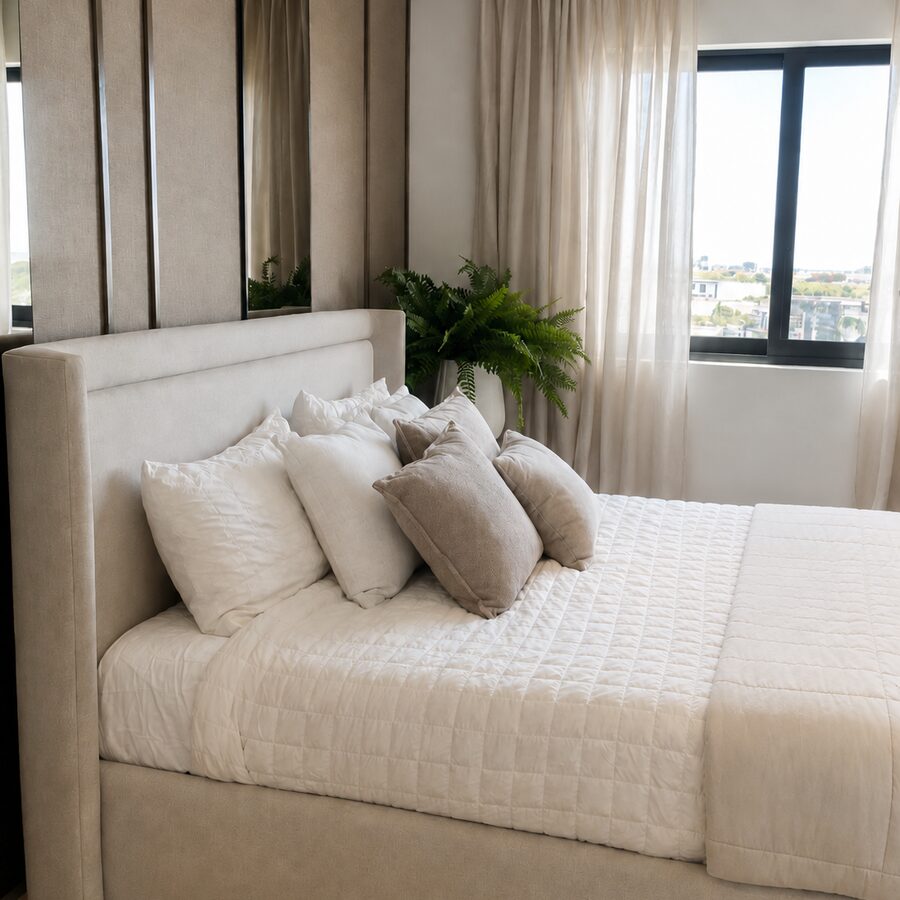 Cama tapizada beige con cabecera acanalada